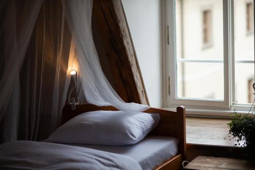 a bedroom with a bed with a curtain and a window at Women's Only Hostel - Female Only in Prague