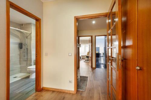 a hallway with a bathroom with a toilet and a shower at Apartamento Girassol - Minho's Guest in Braga