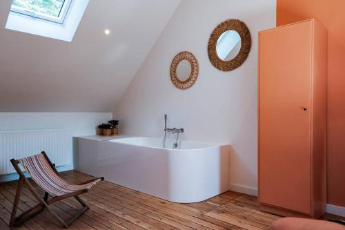 Baño blanco con lavabo y silla en La Maison du Rivage, en Dinant
