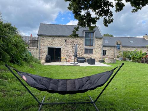 a hammock in a yard in front of a house at Les gîtes d'Izel RDC in Ploemel