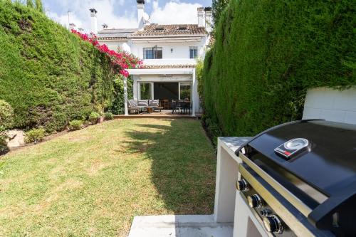 a grill in the yard of a house at Luxury townhouse capricho golden mile in Marbella