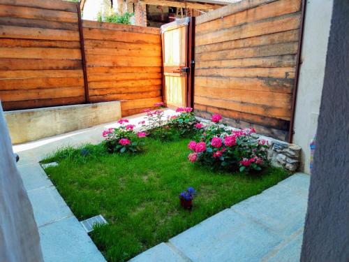a garden with flowers in front of a wooden fence at LaChiura holiday home in Andonno