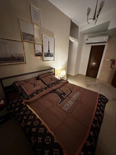 um quarto com uma cama com um cobertor castanho em Studio FLAT in Ajman em Ajman