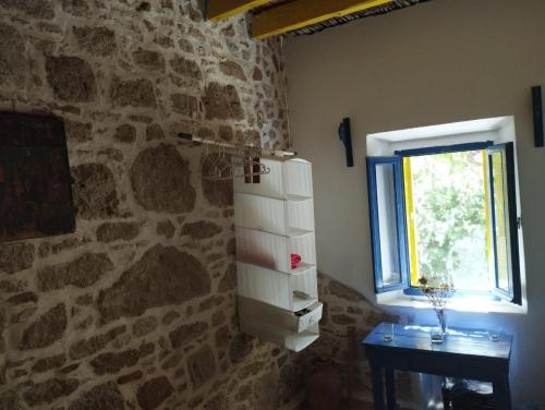 a room with a stone wall and a window at Artist Rooms - Triantafyllou Birth House in Kefalos
