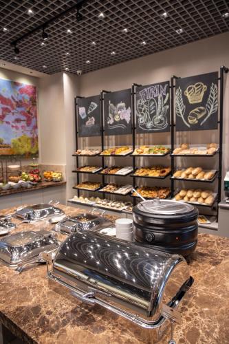 a bakery counter with a bunch of pastries on it at Hilly Hotel in Edirne