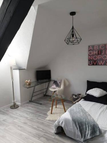 1 dormitorio con 1 cama y escritorio con TV en Studio moderne à Vieux- Thann avec parking privée, 