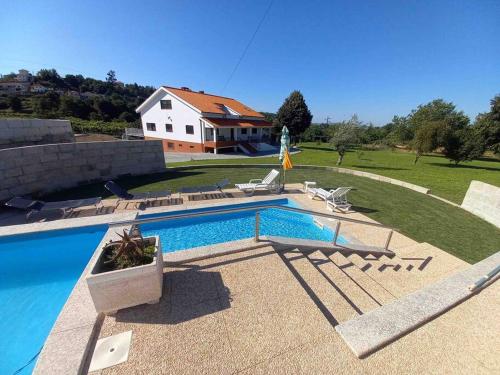 a swimming pool in front of a house at Maison avec piscine : quinta do sol in Amarante