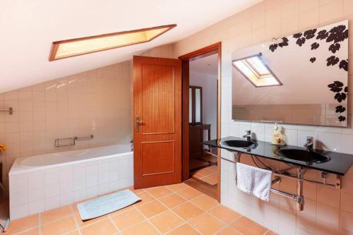 uma casa de banho com uma banheira e 2 lavatórios e uma banheira em Maison avec piscine : quinta do sol em Amarante