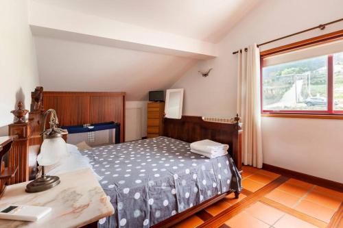 um quarto com uma cama, uma secretária e uma janela em Maison avec piscine : quinta do sol em Amarante