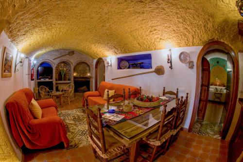 a kitchen and living room with a table and chairs at Casas Cueva Cazorla in Hinojares