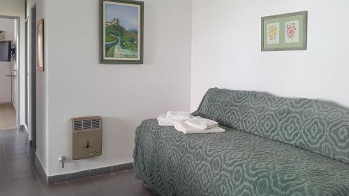 Habitación con cama y ventilador. en Suites Mirage en Pinamar