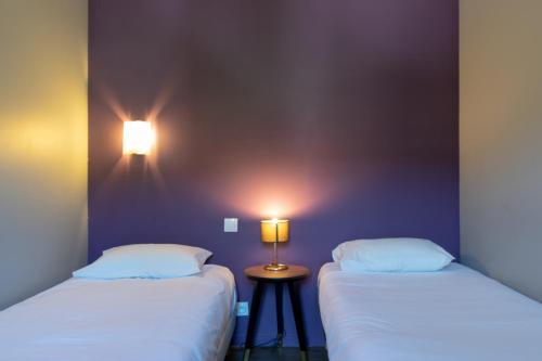two beds sitting next to each other in a room at Hôtel-Restaurant Le Lac in Malbuisson