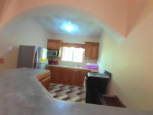 a kitchen with an archway in the middle of it at Mango tree Oasis in Treasure Beach