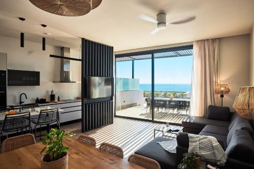 a living room with a couch and a table and a kitchen at Ancón Suites in Carboneras