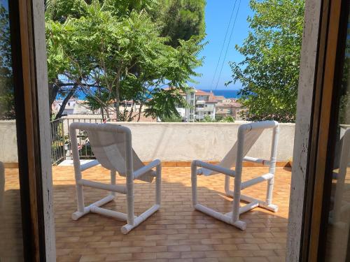 two chairs sitting on a porch with a view at Vista Mare a 300 mt dalla spiaggia in Cariati