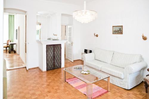 un soggiorno con divano bianco e tavolo di Gabriele´s Apartment a Vienna