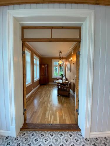 an open door into a living room with a table at Storsand Gård in Trondheim