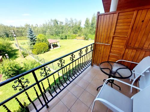 een balkon met stoelen en uitzicht op een tuin bij Nocleg Hotel Nad Stawami in Brzostek