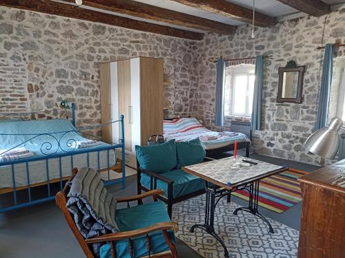 Zimmer mit 2 Etagenbetten und einem Tisch in der Unterkunft 19th century stone house on the seashore in Radovići