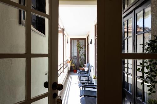 a hallway with blue chairs and a door at Fradelos Porto Centro in Porto