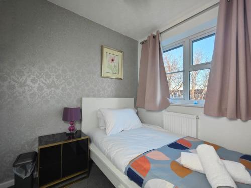 um pequeno quarto com uma cama e uma janela em Tyburn Home, Birmingham with FREE Parking em Birmingham