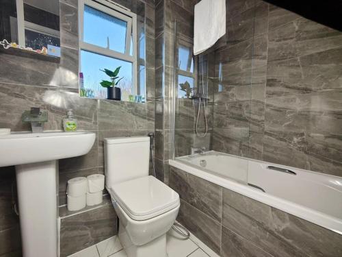 a bathroom with a toilet and a sink and a bath tub at Tyburn Home, Birmingham with FREE Parking in Birmingham