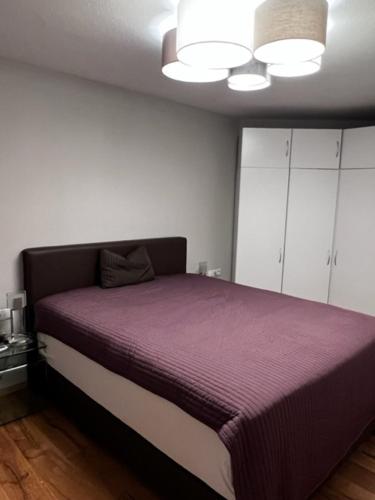 a bedroom with a large bed with a purple blanket at Heidis Ferienwohnung in Kramsach