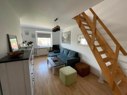 ein Wohnzimmer mit einem blauen Sofa und einer Treppe in der Unterkunft Apartament Bea Mar in Gdynia