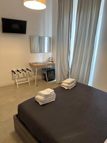 een slaapkamer met een bed met twee handdoeken erop bij San Martino Rooms Third Floor No Lift in La Spezia