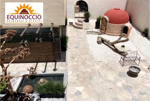 a building with a sign and a fountain in a courtyard at Posada Equinoccio in Bernal