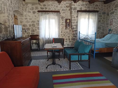 a living room with a bed and a table at 19th century stone house on the seashore in Radovići