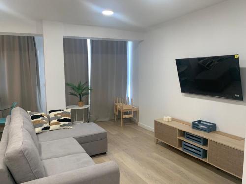 a living room with a couch and a flat screen tv at Piso Calle Murcia in Almería