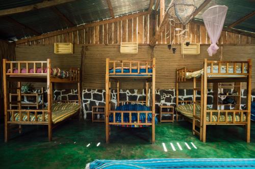 a room with four bunk beds in a barn at Eco-Hotel Mayachik in San Juan La Laguna