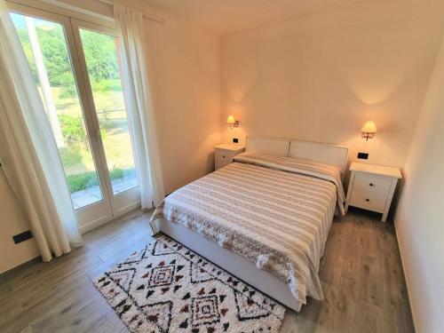 a bedroom with a bed and a large window at Oasi di pace nella Val di Taro in Compiano