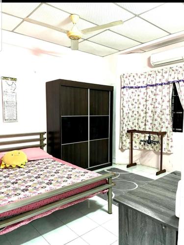 sypialnia z łóżkiem i wentylatorem sufitowym w obiekcie Homestay lumut manjung murah w mieście Lumut