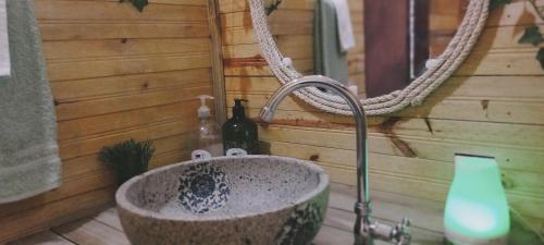 - un lavabo dans la salle de bains avec une bouteille de vin dans l'établissement Iwaglamping, à La Peña