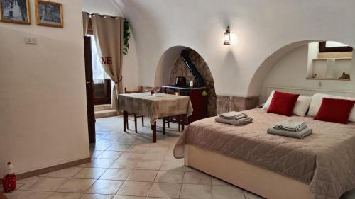 a bedroom with a bed and a table in a room at La Locanda di Nonno Paolo in Altamura