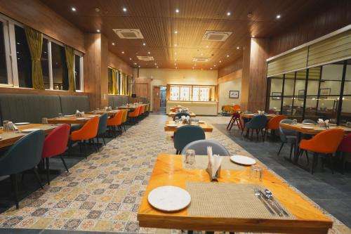 a dining room with wooden tables and chairs at Hotel CP Palace in Patna