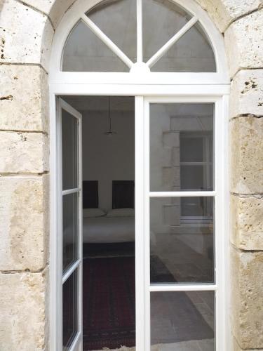 a white window in a brick wall with a couch behind it at Chartreuse du XVIIIe in Saint-Créac