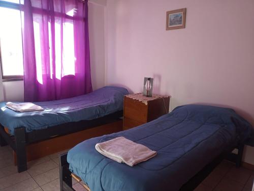 Habitación con 2 camas individuales y ventana. en Departamento Bombal Mendoza en Mendoza