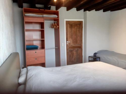 a bedroom with a bed and a dresser and a closet at Holidayhouse Balie in Bruges