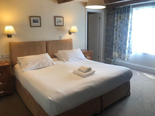 a bedroom with a bed with two towels on it at Trehellas House Hotel & Courthouse restaurant in Bodmin