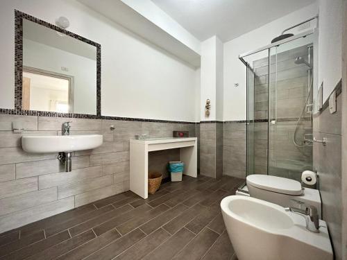 a bathroom with a sink and a toilet and a mirror at Il Gioiello a Palau in Palau
