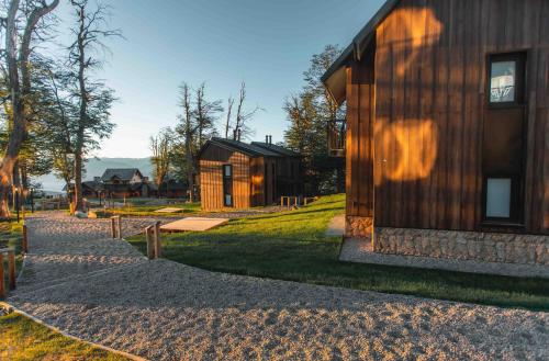 una casa de madera con un camino que conduce a ella en El Refugio Ski & Summer Lodge en San Martín de los Andes