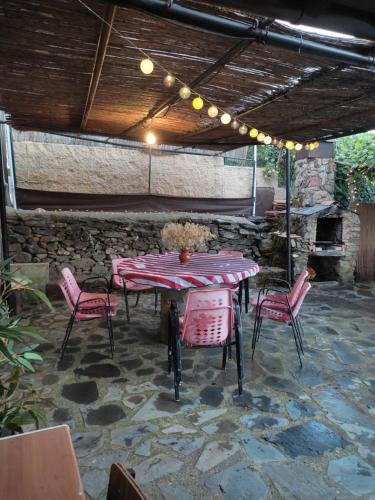 un patio con mesa y sillas bajo un techo en An'Ca' La Pura en Villanueva del Conde