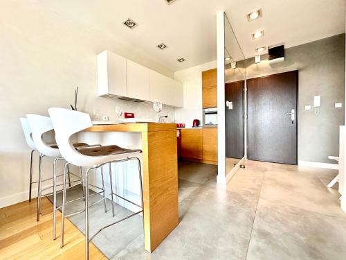 uma cozinha com cadeiras brancas e um balcão num quarto em PODWALE 2 Apartment - Self Check-In 20h ~Parking & Lift em Breslávia