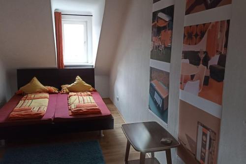 Retrowohnung im Herzen von Graz في غراتس: غرفة نوم صغيرة بها سرير وكرسي