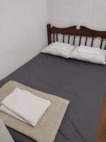 two beds with white pillows in a room at Casa no Centro em DM - 500 metros rua de lazer in Domingos Martins