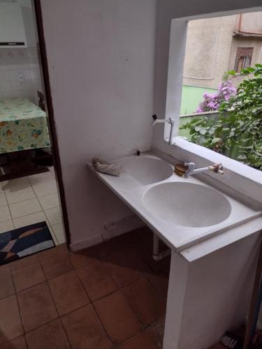 lavabo blanco en un baño con ventana en Casa no Centro em DM - 500 metros rua de lazer, en Domingos Martins