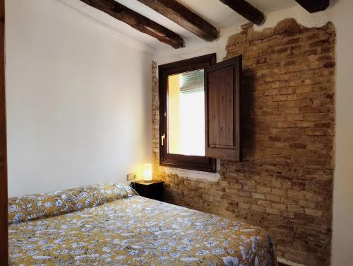 a bedroom with a bed and a brick wall at Apartamento Tarragona centro histórico in Tarragona